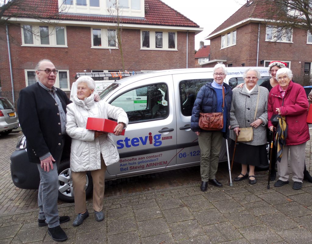 Jan Lareman staat met bewoners uit Geitenkamp naast de nieuwe StevigArnhem bus.